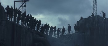 Movie still from “Reign of Fire” (2002), directed by Rob Bowman – A group of people standing at the top of a staircase; Extreme Wide shot, Low angle