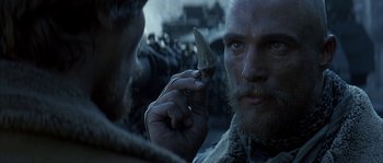 Movie still from “Reign of Fire” (2002), directed by Rob Bowman – A person holding a small object in their hand; Close Up shot, Over the shoulder angle
