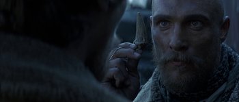 Movie still from “Reign of Fire” (2002), directed by Rob Bowman – A person holding a knife in their hand; Close Up shot, Over the shoulder angle