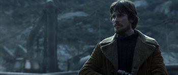 Movie still from “Reign of Fire” (2002), directed by Rob Bowman – A person holding a gun in a forest; Medium shot, Over the shoulder angle