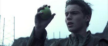 Movie still from “Reign of Fire” (2002), directed by Rob Bowman – A man holding an apple in his right hand; Close Up shot, Low angle