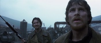 Movie still from “Reign of Fire” (2002), directed by Rob Bowman – Two men standing next to each other on a field; Close Up shot, Low angle
