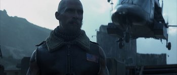 Movie still from “Reign of Fire” (2002), directed by Rob Bowman – A bald man with a flag on his neck; Close Up shot, Low angle