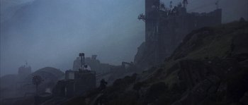 Movie still from “Reign of Fire” (2002), directed by Rob Bowman – A man standing on top of a hill next to a building; Extreme Wide shot, Low angle