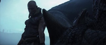 Movie still from “Reign of Fire” (2002), directed by Rob Bowman – A man standing next to a large bird; Medium shot, Low angle