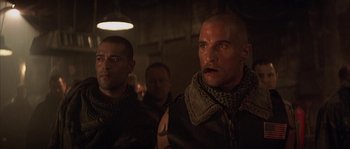Movie still from “Reign of Fire” (2002), directed by Rob Bowman – A group of men standing next to each other in a dark room; Close Up shot, Low angle