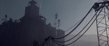 Movie still from “Reign of Fire” (2002), directed by Rob Bowman – A large building with many wires hanging from it's roof; Extreme Wide shot, Low angle