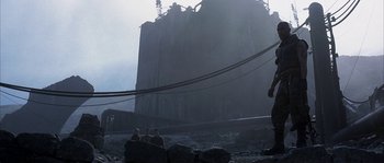 Movie still from “Reign of Fire” (2002), directed by Rob Bowman – A group of people sitting on top of a hill; Extreme Wide shot, Low angle