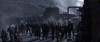 Movie still from “Reign of Fire” (2002), directed by Rob Bowman – A group of people standing next to each other on top of a hill; Wide shot, High angle