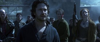 Movie still from “Reign of Fire” (2002), directed by Rob Bowman – A man standing in front of a group of people; Close Up shot, Over the shoulder angle