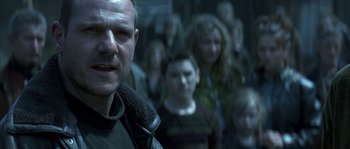 Movie still from “Reign of Fire” (2002), directed by Rob Bowman – A group of people standing in front of each other; Close Up shot, Low angle