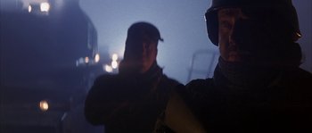 Movie still from “Reign of Fire” (2002), directed by Rob Bowman – Two men are standing in the dark and one of them is wearing a hat; Close Up shot, Low angle