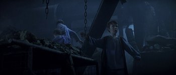 Movie still from “Reign of Fire” (2002), directed by Rob Bowman – A group of people standing next to each other in a dark room; Medium shot, Low angle