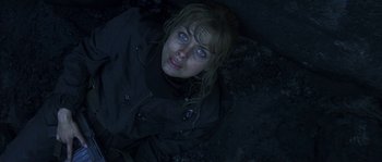 Movie still from “Reign of Fire” (2002), directed by Rob Bowman – A woman with blue eyes laying on the ground in the dark; Close Up shot, Overhead angle