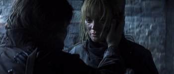 Movie still from “Reign of Fire” (2002), directed by Rob Bowman – A woman with blonde hair is holding her head; Close Up shot, Over the shoulder angle