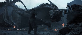 Movie still from “Reign of Fire” (2002), directed by Rob Bowman – A man standing in front of a large dragon; Wide shot, Low angle