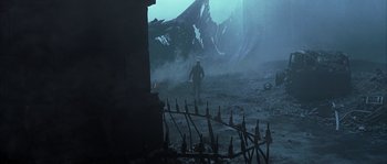 Movie still from “Reign of Fire” (2002), directed by Rob Bowman – A man is walking through a dark forest; Wide shot, High angle