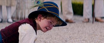 Movie still from “Remi, Nobody's Boy” (2018), directed by Antoine Blossier – A young boy wearing a blue hat with a peacock feather on it; Close Up shot, High angle