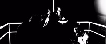 Movie still from “Renaissance” (2006), directed by Christian Volckman – A black and white photo of a man and a cat; Extreme Close Up shot, Low angle