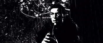 Movie still from “Renaissance” (2006), directed by Christian Volckman – A black and white image of a man holding a knife in his hand; Extreme Close Up shot, Low angle