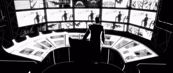 Movie still from “Renaissance” (2006), directed by Christian Volckman – A man sitting in front of a bunch of screens; Wide shot, Low angle