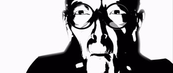 Movie still from “Renaissance” (2006), directed by Christian Volckman – A black - and - white photo of a man with glasses; Extreme Close Up shot, Overhead angle