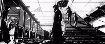 Movie still from “Renaissance” (2006), directed by Christian Volckman – A black and white image of a man walking down a staircase; Wide shot, Low angle