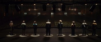 Movie still from “Rent” (2005), directed by Chris Columbus – A group of people standing in front of an empty auditorium; Wide shot, High angle