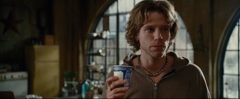 Movie still from “Rent” (2005), directed by Chris Columbus – A man holding a cup in his right hand; Close Up shot, Over the shoulder angle