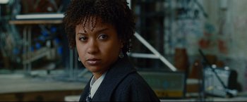 Movie still from “Rent” (2005), directed by Chris Columbus – A person wearing a suit and tie; Close Up shot, Over the shoulder angle