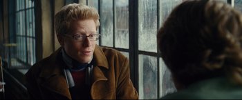 Movie still from “Rent” (2005), directed by Chris Columbus – A man in glasses and a brown jacket looking at another man in glasses; Close Up shot, Over the shoulder angle