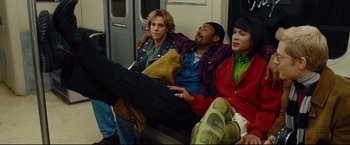 Movie still from “Rent” (2005), directed by Chris Columbus – A group of people sitting on top of a train; Medium shot, High angle
