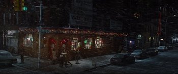 Movie still from “Rent” (2005), directed by Chris Columbus – A group of people standing in front of a building at night; Extreme Wide shot, High angle