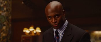 Movie still from “Rent” (2005), directed by Chris Columbus – A man in a suit and tie with a serious look on his face; Close Up shot, Low angle