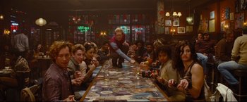 Movie still from “Rent” (2005), directed by Chris Columbus – A group of people sitting around a table; Wide shot, High angle