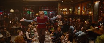 Movie still from “Rent” (2005), directed by Chris Columbus – A man in a red and blue shirt is in front of a group of people; Wide shot, High angle