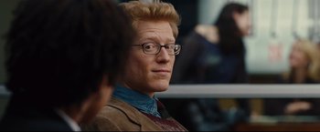 Movie still from “Rent” (2005), directed by Chris Columbus – A person wearing glasses and a jacket; Close Up shot, Over the shoulder angle