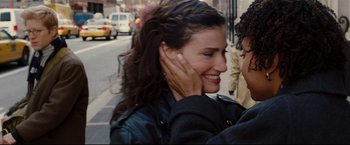 Movie still from “Rent” (2005), directed by Chris Columbus – A young woman smiling while holding a man's ear; Close Up shot, High angle