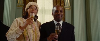 Movie still from “Rent” (2005), directed by Chris Columbus – A man and a woman are holding champagne glasses; Medium shot, Low angle
