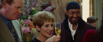 Movie still from “Rent” (2005), directed by Chris Columbus – A woman holding a wine glass in front of a man; Close Up shot, Over the shoulder angle