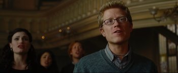 Movie still from “Rent” (2005), directed by Chris Columbus – A person wearing glasses and a sweater; Close Up shot, Low angle