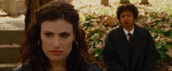 Movie still from “Rent” (2005), directed by Chris Columbus – A woman and a man standing next to each other in a forest; Close Up shot, Over the shoulder angle
