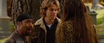 Movie still from “Rent” (2005), directed by Chris Columbus – A man with long blonde hair wearing a brown jacket; Close Up shot, Over the shoulder angle