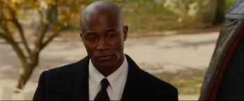 Movie still from “Rent” (2005), directed by Chris Columbus – A man in a suit and tie looking to his left; Close Up shot, High angle