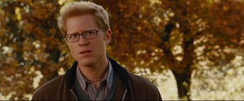 Movie still from “Rent” (2005), directed by Chris Columbus – A person wearing glasses and a jacket; Close Up shot, Over the shoulder angle