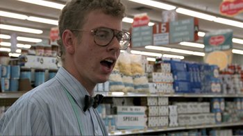 Movie still from “Repo Man” (1984), directed by Alex Cox – A man with a bow tie in a grocery store; Close Up shot, Low angle