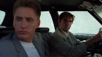 Movie still from “Repo Man” (1984), directed by Alex Cox – A man and a boy sitting in the back seat of a car; Close Up shot, Low angle