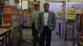 Movie still from “Repo Man” (1984), directed by Alex Cox – Two men standing in front of a store entrance; Medium shot, Low angle