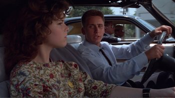 Movie still from “Repo Man” (1984), directed by Alex Cox – A man and a woman driving a car in the back of a car; Close Up shot, Over the shoulder angle