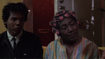 Movie still from “Repo Man” (1984), directed by Alex Cox – An older woman with curlers in her hair; Close Up shot, Over the shoulder angle